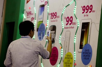 Seorang penunjung tampak mengabadikan harga ponsel dan modem termurah yang dibanderol mulai dari harga puluhan ribu rupiah.