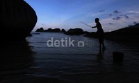 Seorang warga tampak memancing.