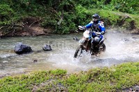 Seorang peserta Surya Autology Xtrime Sumatera eXpedition melintasi sungai.