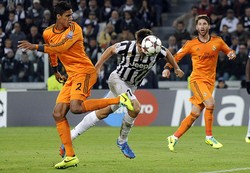 Fernando Llorente menyundul bola untuk melewati Raphael Varane. Reuters/Giorgio Perottino.