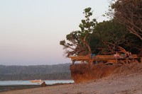 Beberapa turis sedang asyik bersantai di bangku kayu di Joyos Surf Camp yang ada di pinggir Pantai G-Land. Ada yang mendengarkan musik, membaca buku, atau hanya menyaksikan mentari yang perlahan tenggelam (Afif/detikTravel)