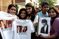 Fans berpose sambil memengang kaus putih yang bergambar wajah SRK dan bertuliskan 'Keep calm and love srk forever'. AFP PHOTO/STR.