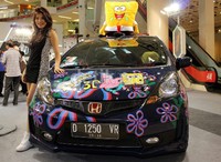 Model berpose dengan mobil peserta Honda Jazz Tuning Contest.