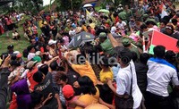 Warga berebut gunungan apem dan hasil bumi dalam tradisi 'Apem Sewu' di Kampung Sewu. Tradisi ini untuk melengkapi acara Festival Getek.