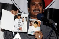     Ma'mun Murod menunjukkan surat Yassin bergambar Edhie Baskoro Yudhoyono dan Aliya Rajasa. Buku yassin yang ditemukan di rumah Anas itu tidak ikut disita oleh KPK.