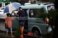 Sejumlah pejalan kaki menggunakan jasa ojek payung salah satu pusat perbelanjaan di Kuningan, Jakarta Selatan.