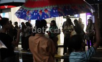 Sejumlah anak kecil dan remaja berdiri sambil membawa payung di tangannya. Mereka cukup diam menanti lambaian tangan orang-orang yang membutuhkan jasanya.