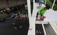  Beberapa orang pekerja mengerjakan lantai JPO yang terbuat dari almunium.