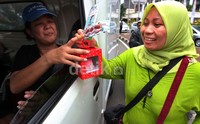 Mereka membbagikan souvenir dan selebaran kepada para pengendara yang melintas.