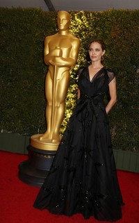 Jolie tampak anggun dan elegan lewat balutan gaun lace hitam yang menyapu lantai dari Atelier Versace. REUTERS/Fred Prouser.