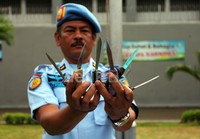 Petugas menunjukan senjata tajam yang berhasil disita.