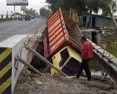Jalan Menyempit, Truk Muat Kayu Nyungsep ke Sungai