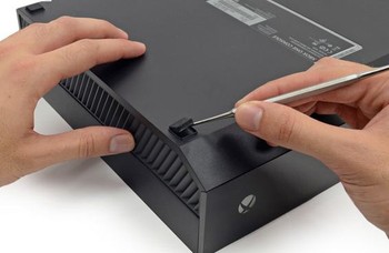 Untuk membongkar Xbox One pertama-tama pengguna terlebih dahulu membuka skrub yang disembunyikan di balik bantalan kaki. (credit foto: iFixit)