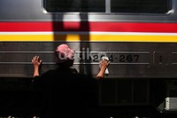 Seorang pekerja membersihkan eksterior kereta.