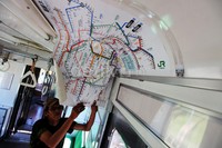     Seorang pekerja melepas peta rute di atap kereta.