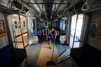 Seorang pekerja membersihkan lantai kereta.