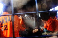 Selain dengan pengawalan ketat anggota kepolisian, 19 narapidana tersebut juga diborgol tangan dan kakinya.