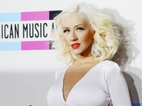     Polesan lipstik merah di bibirnya yang terlihat kontras dengan rambut  dan dress-nya, membuat pelantun 'Beautiful' itu tampil berseri-seri. REUTERS/Mario Anzuoni.