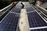 Petugas membersihkan dan mengecek baut panel surya.