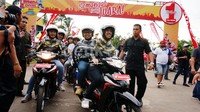Dengan sumringah mereka tampak duduk di atas motor Honda.