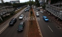 Pengendara melintas di samping bonggol pohon yang telah ditebang di median jalan karena terkena dampak proyek MRT di kawasan Jalan Sudirman, Jakarta, Selasa (26/11/2013).
