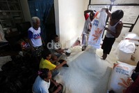 Sejumlah warga mengeluarkan beras dari dalam karung untuk dibagikan kepada keluarga miskin di Klender, Jakarta Timur, Rabu (27/11/2013).