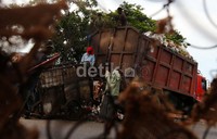 Petugas kebersihan menaiki sampah ke atas truk sampah di kawasan Jakarta Utara, Rabu (27/11/2013).