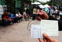 Warga menunjukkan Radio Frequency Identification (RFID) yang akan dipasang di mobilnya.