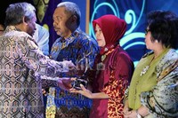Menteri Pendidikan dan Kebudayaan Republik Indinesia Mohammad Nuh (kiri), memberikan selamat kepada Tri Rini Widiyastuti seorang guru yang mengajar pada anak-anak Suku Anak Dalam. Rini, juga merupakan pengelola Sekolah Alam Putri Tijah di Taman Nasional Bukit Dua Belas, binaan Astra Agro Lestari.