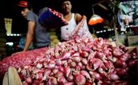 Seorang pedagang tampak membersihkan dan menimbang bawang merah jualannya di kawasan Pasar Kramat Jati, Jakarta TImur, Senin (2/12/2013).