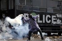 Pendemo melemparkan kembali gas air mata yang ditembakkan polisi. Reuters/Damir Sagolj.