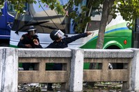 Seorang polisi membalas dengan melempari pendemo dengan berbagai macam benda. Reuters/Athit Perawongmetha.