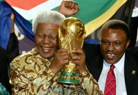 Mandela memegang trofi Piala Dunia di markas FIFA di Zurich pada 15 Mei 2004. Saat itu Afrika Selatan terpilih sebagai tuan rumah Piala Dunia. AFP/Franck Fife.
