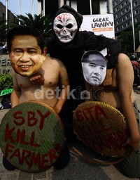 Massa memakai topeng SBY dan Mendag Gita Wirjawan yang membawa tulisan SBY dan Gita kill farmers.