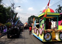 Kendaraan berhiaskan bunga dengan mimbar tempat artis berdiri.