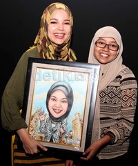 Dewi Sandra diberi hadiah oleh salah seorang mahasiswa yang mengidolakan dirinya.