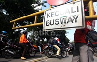 Petugas Satgas TransJakarta berusaha menutup portal untuk mencegah para pengendara motor memasuki jalur TransJakarta.