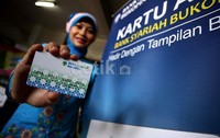 Seorang teller menunjukkan kartu ATM Bank Syariah Bukopin di Jakarta, Senin (9/12/2013). PT Bank Syariah Bukopin membukukan laba bersih sebesar Rp24,33 miliar hingga November 2013. Perolehan ini naik 28,32 persen jika dibanding perolehan periode yang sama pada tahun lalu sebesar Rp18,96 miliar.