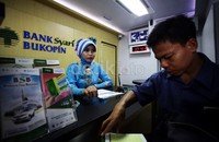 Teller Bank Syariah Bukopin melayani nasabah.
