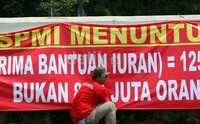 Massa membawa bendera dan spanduk bertuliskan tuntutan Jaminan Kesehatan.