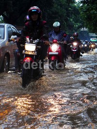 Pemotor nekat menerobos genangan.