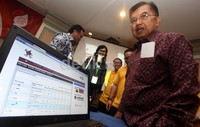 Ketua PMI Jusuf Kalla mendemonstrasikan aplikasi Bloodbook saat jumpa pers di Hotel Grand Sahid, Jakarta, Senin (16/12/2013).
