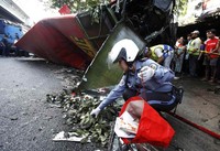 Seorang polisi mengambil sepatu seorang penumpang yang tewas. REUTERS/Romeo Ranoco.