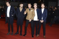 Kelima personel One Direction tampil kompak mengenakan setelan jas dan coat. Pascal Le Segretain/Getty Images.