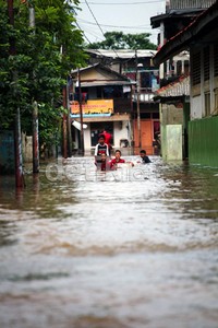 Banjir dimanfaatkan sejumlah anak untuk bermain air.