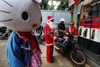 Satu persatu para pengendara sepeda motor menerima permen yang dibagikan Sinterklas.