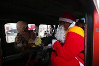 Sinterklas menyapa dan membagikan permen kepada penumpang angkutan kota.