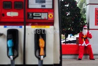 Sinterklas menunggu para pengendara motor maupun mobil yang akan mengisi BBM.