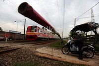 Pintu perlintasan KA tertutup saat kereta melintas.