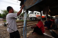 Sejumlah warga berjaga di pintu perlintasan. Apabila ada kereta yang melintas, mereka langsung menutup pintu perlintasan.